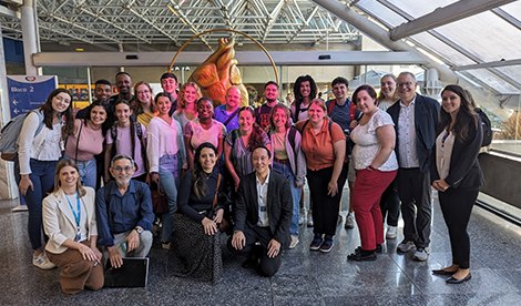 A big group smiles in an airport.