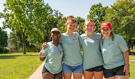 4 students smile on campus