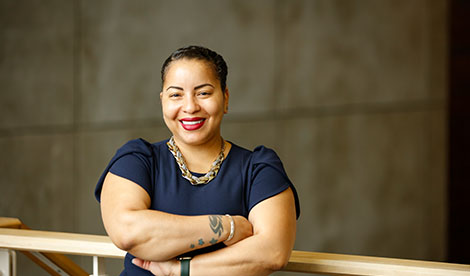 A woman crosses her arms and smiles.