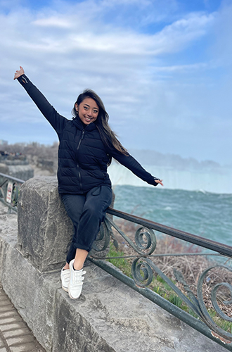 Aeva poses in front of a waterfall.