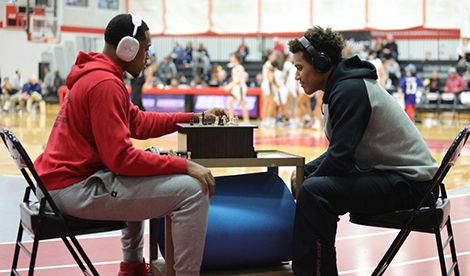 2 Roberts basketball teammates play a game of chess.