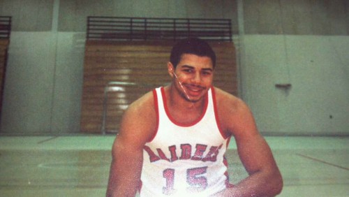 David Brown as a college student wearing a Roberts basketball uniform and smiling.