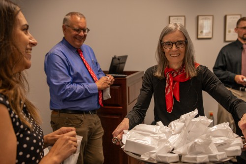 Dr. Berry holds tray of ice cream treats and smiles