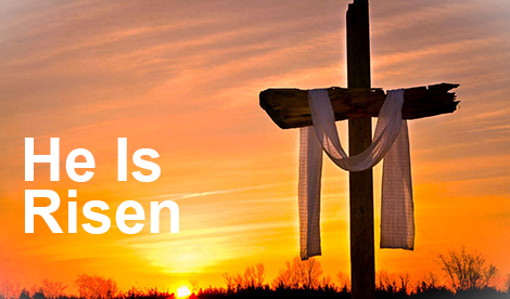 An image of a sunset with a cross in the foreground. There are white words overlayed - He Is Risen.