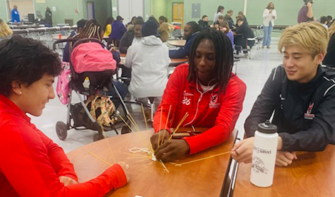 3 students play with dry pasta