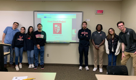 Students stand in front of presentation on a screen