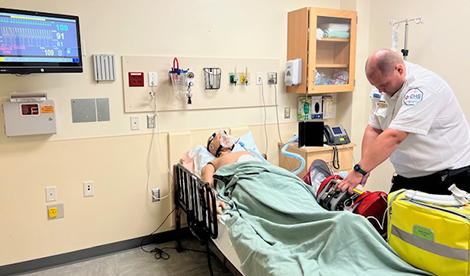 A healthcare worker practices on a mannequin patient in the simulation center