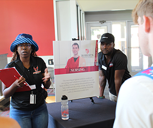 A young woman speaks to visitors.