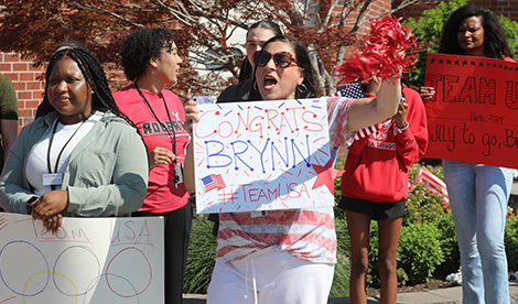 Roberts' staff members hold signs and cheer.