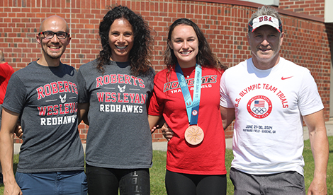 Brynn smiles with coach Jenn Suhr and others