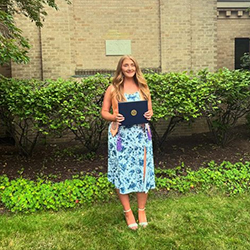 Orla Hastings smiles with diploma