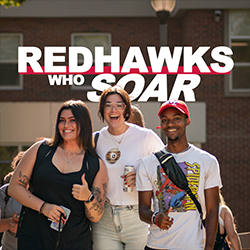 3 students smile on campus with the words Redhawks Who Soar above them