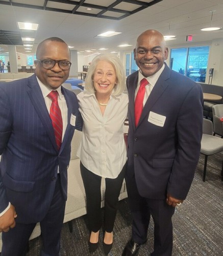 Simo and President Hayles smile with a woman.