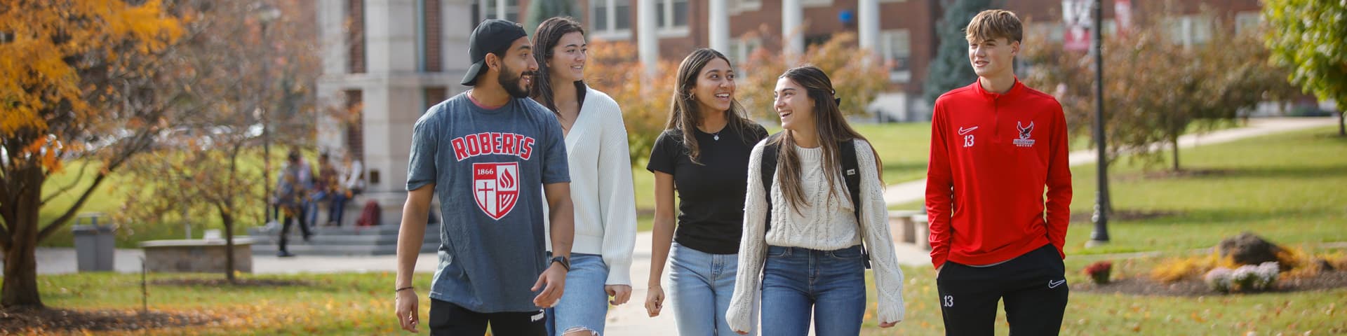 5 students walk across campus