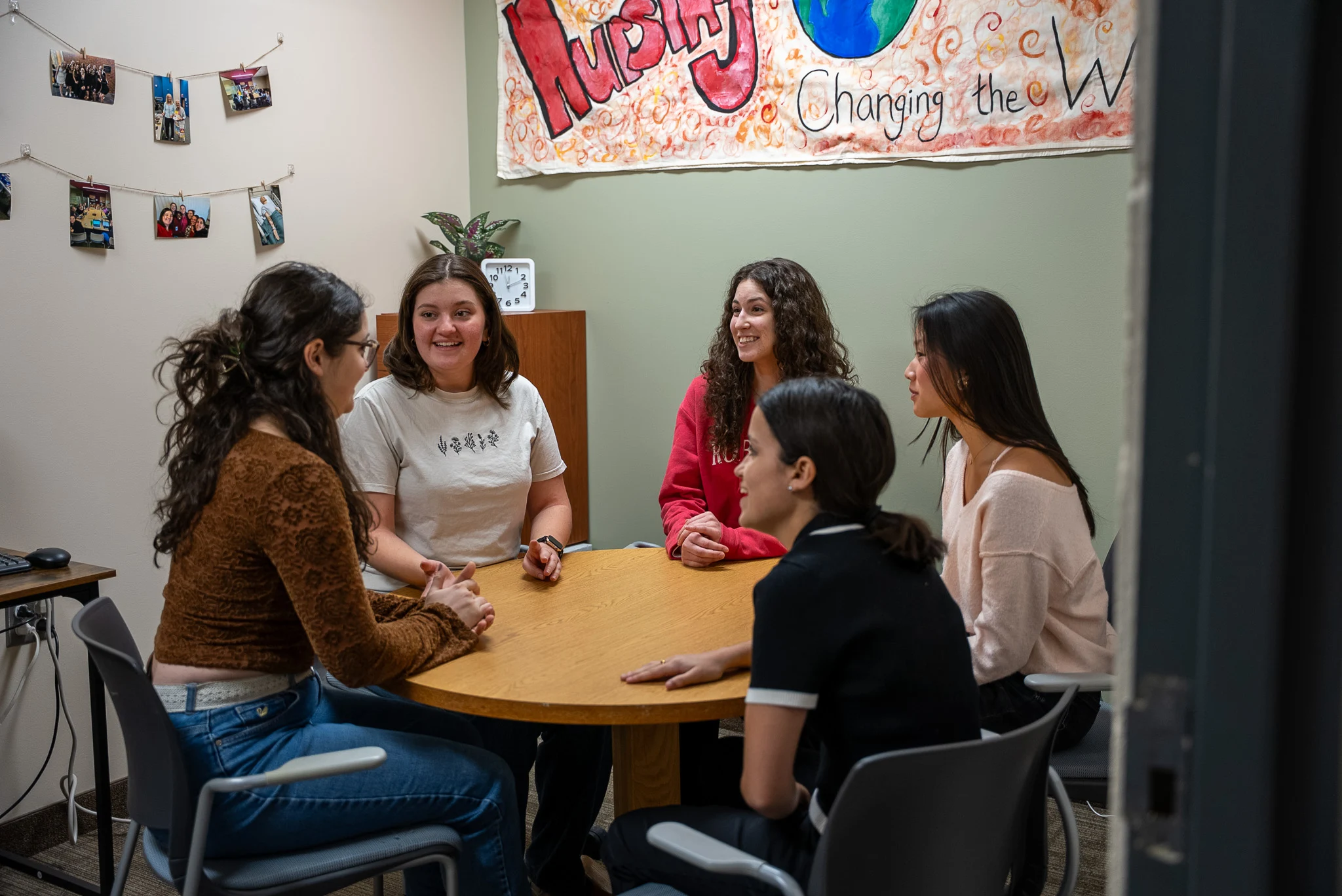 Roberts wesleyan university nursing club students sitting around a table in a meeting