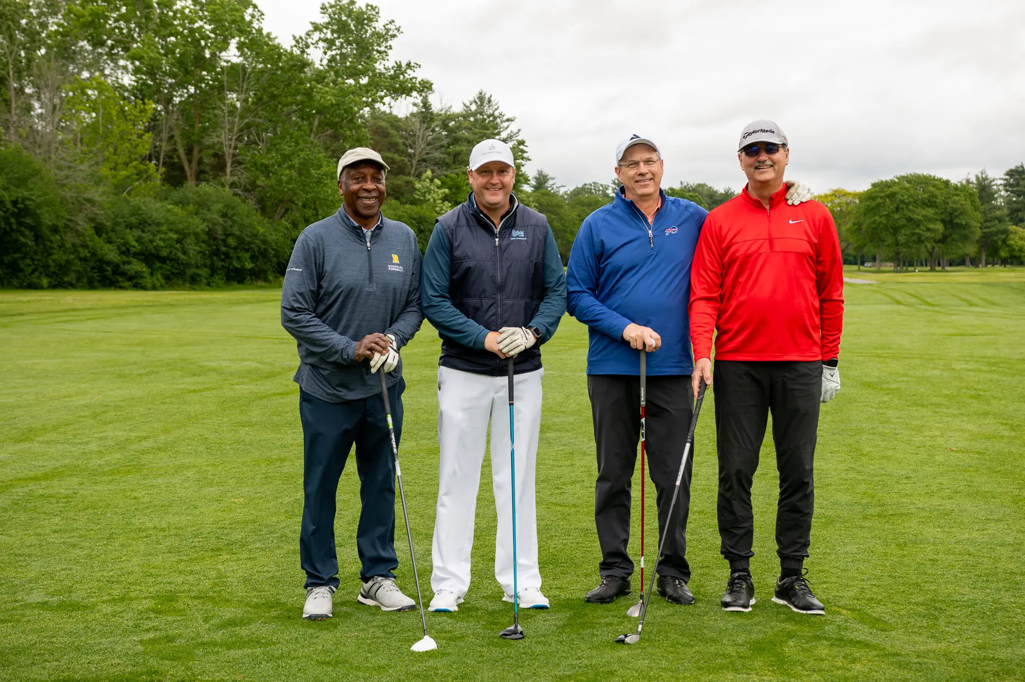 4 golfers stand and smile