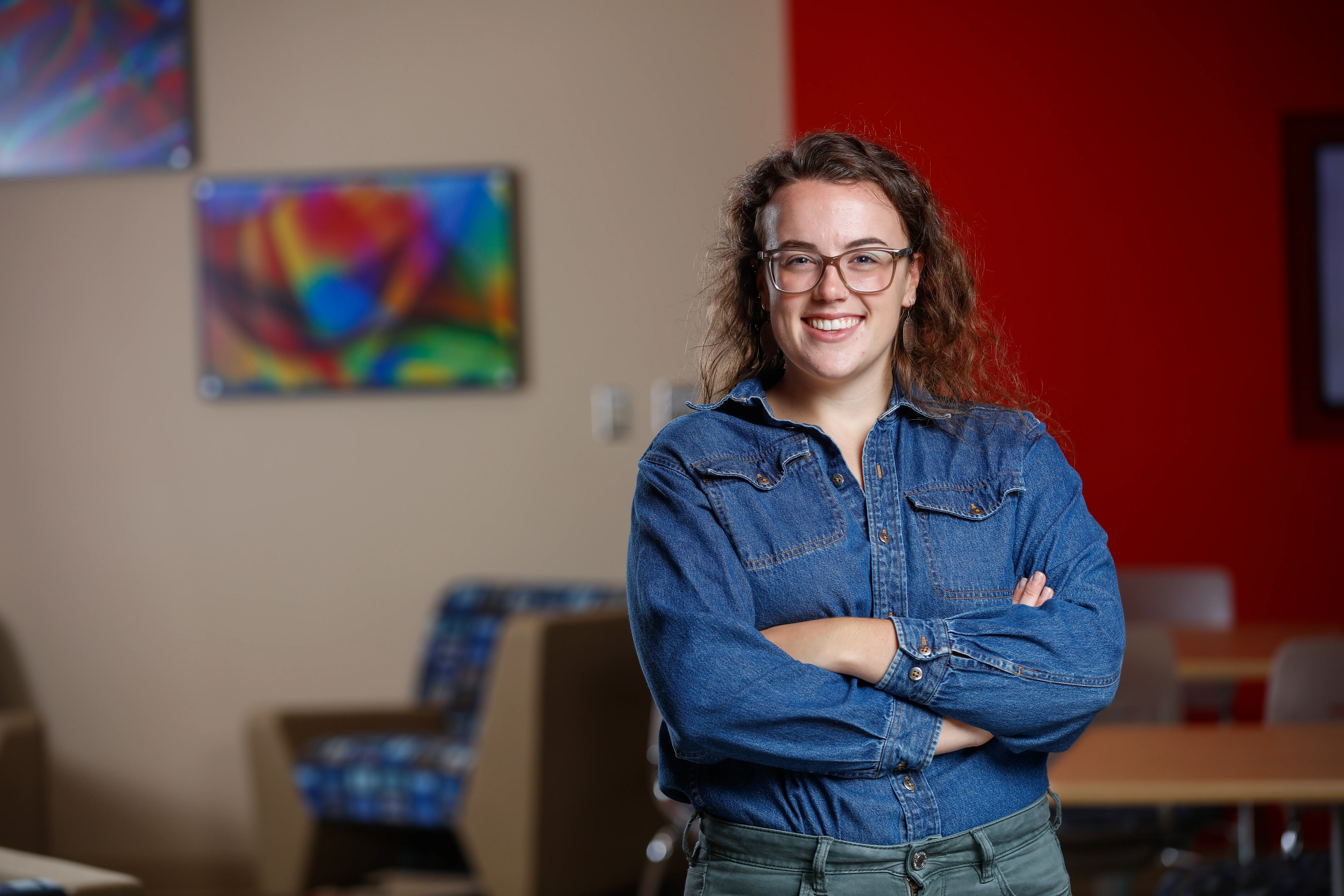 A woman stands and smiles