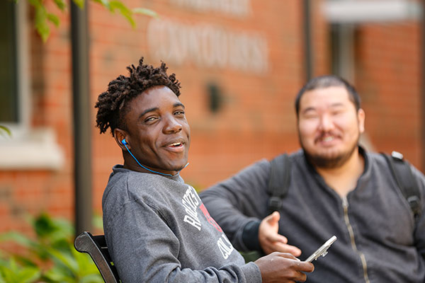 Two students sitting on the bench at Roberts Wesleyan University