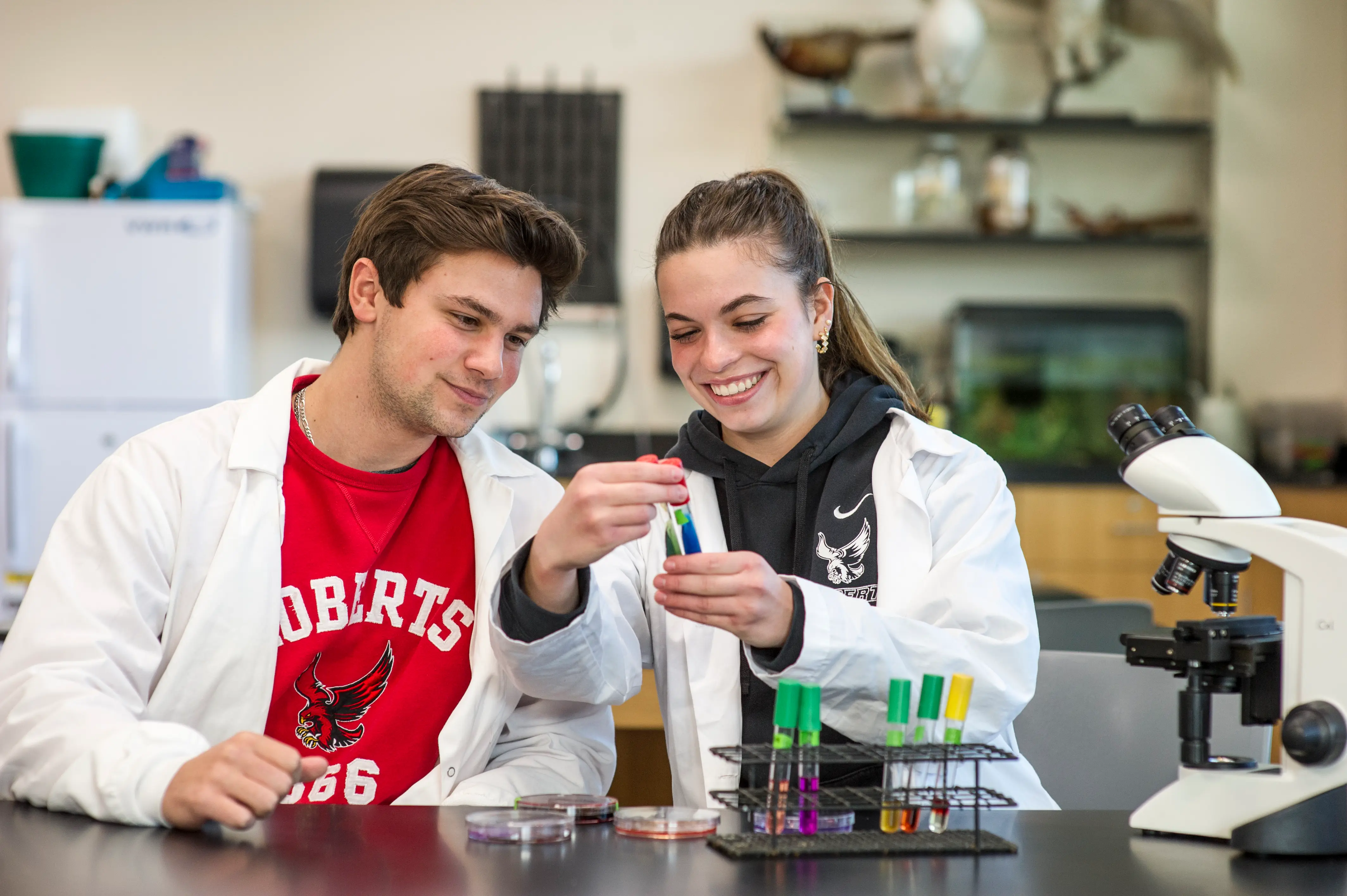 Nat and Avery looking at test tubes